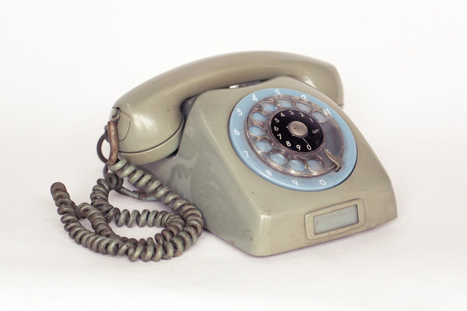 1980s retro telephone in dirty green with baby blue dial.